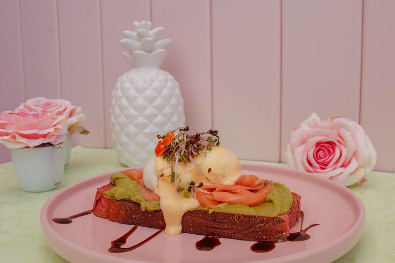Brunch da Nês com ovos e sanduíche servidos num prato rosa